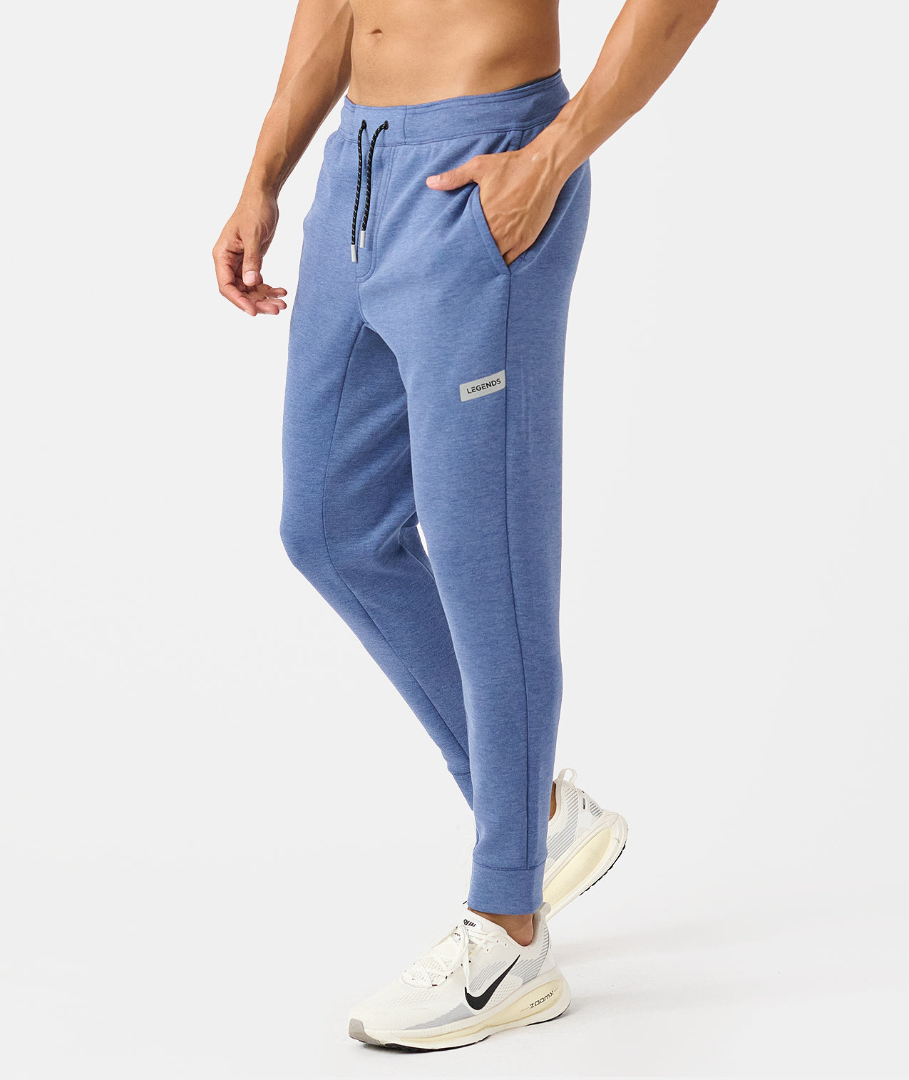 Men's heather blue joggers with drawstring waist, side pockets, and branded label patch on thigh. - 3