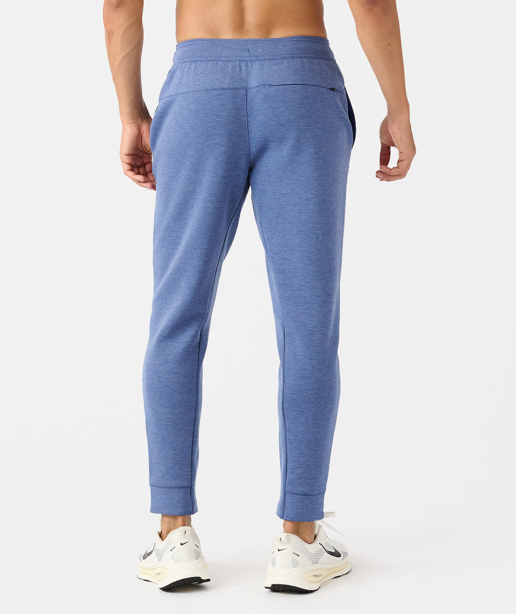 Man wearing blue heather joggers with elastic waistband and cuffed ankles, shown from behind. - 2