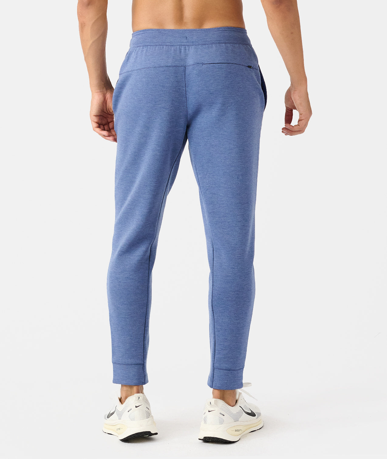 Man wearing blue heather joggers with elastic waistband and cuffed ankles, shown from behind. - 2