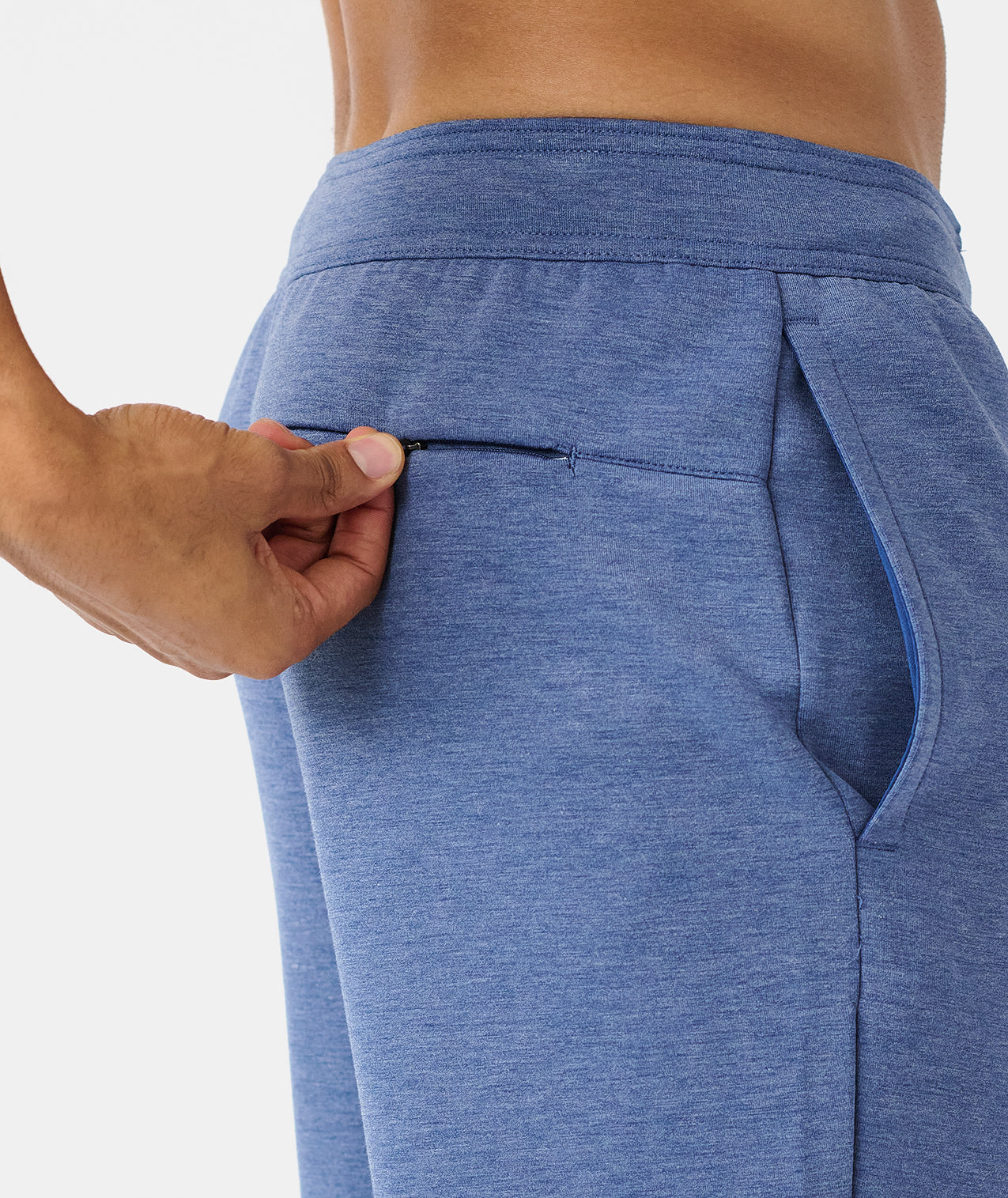 Heather blue jogger pants with elastic waistband and side pockets, shown on model from waist down. - 6