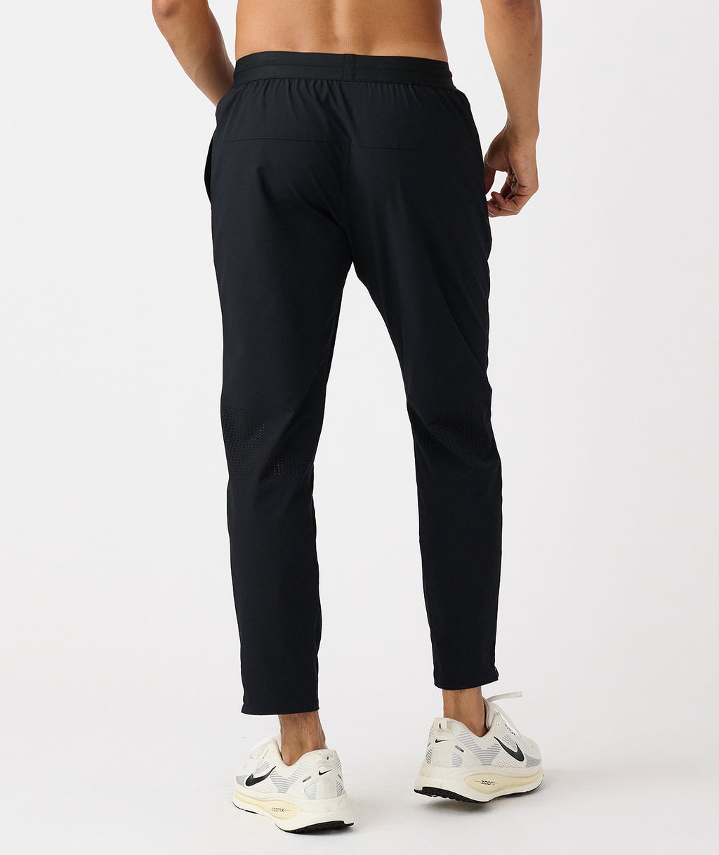 Black tapered athletic pants with elasticated waistband and mesh vents at the calves. - 2